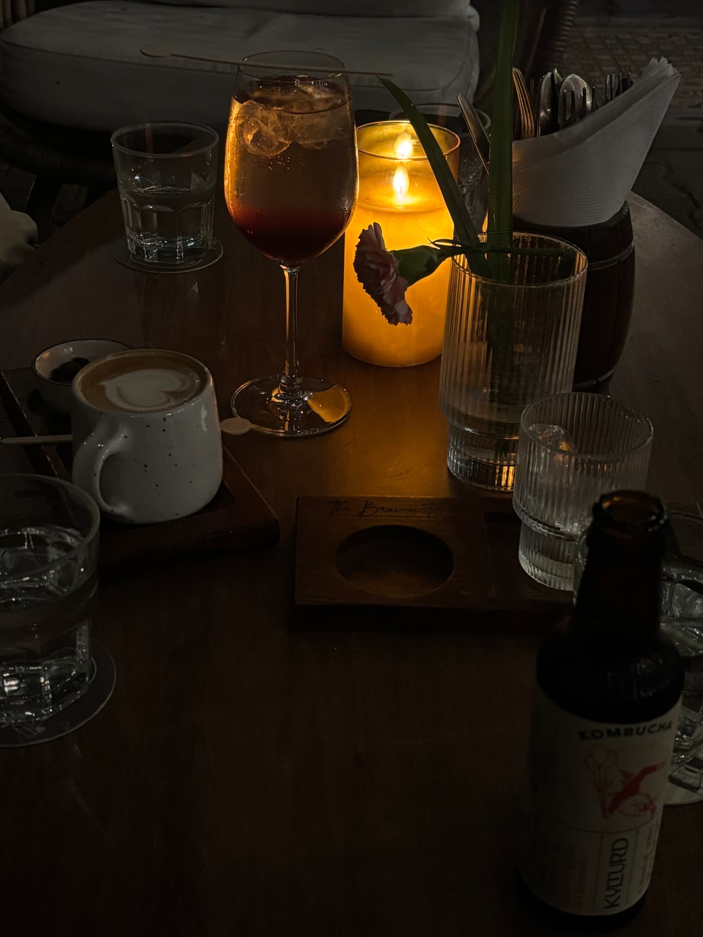 Candlelit table with drinks, coffee and a flower