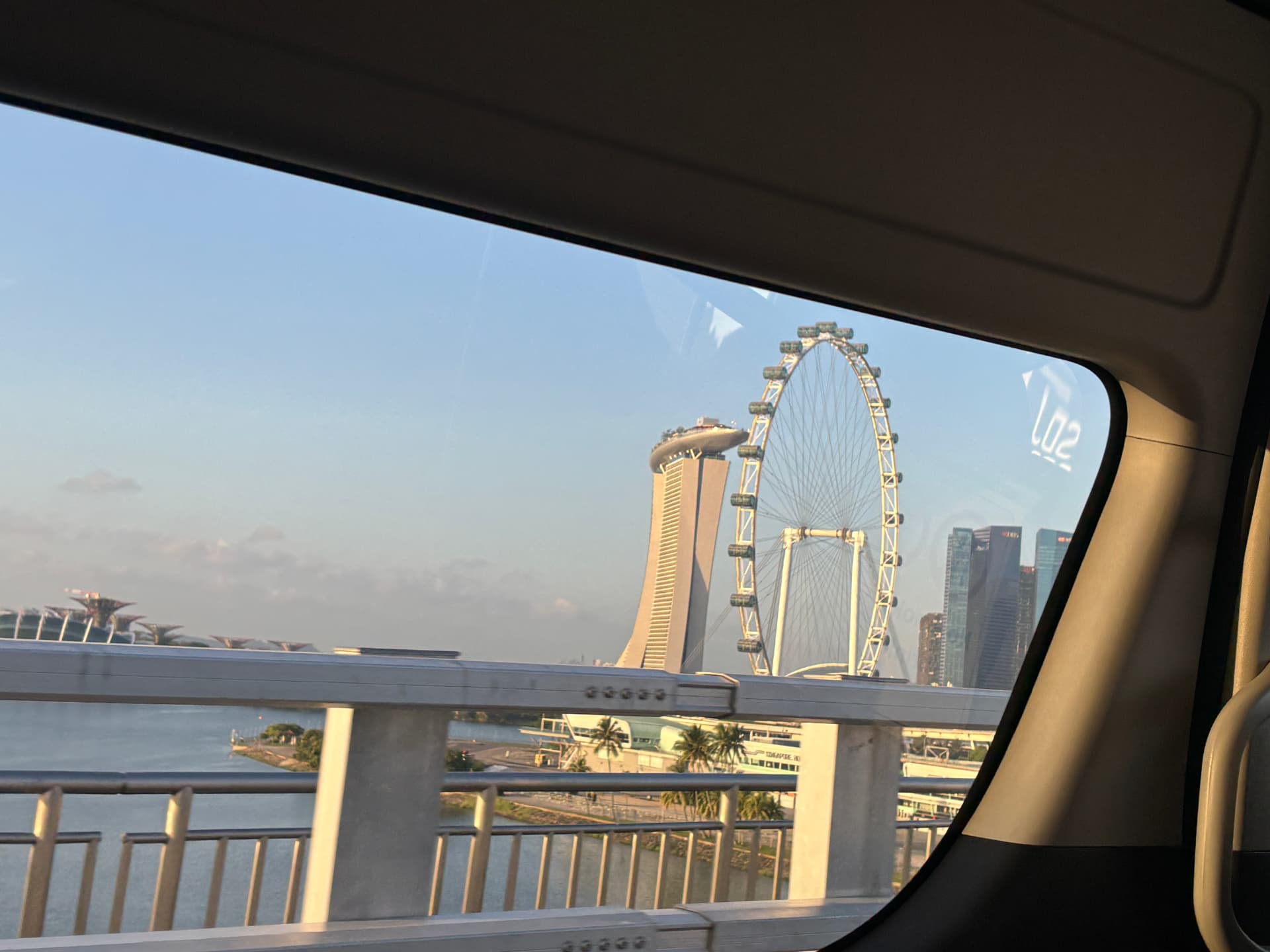 Observation wheel and waterfront skyline seen through a car window
